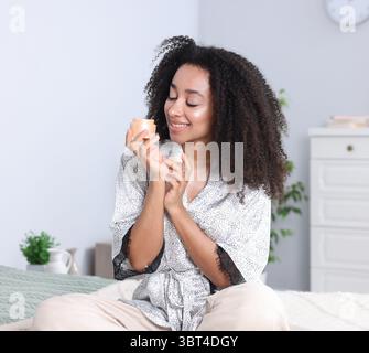 Bella donna brasiliana con barattolo di crema al collagene al chiuso Foto Stock
