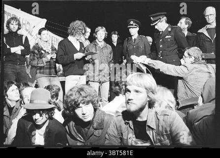 BAN (Break Atomic Chain Netherlands) attua un blocco stradale per impedire che i residui radioattivi provenienti dall'ECN di Petten vengano trasportati su strada fino a IJmuiden, dove saranno spediti per essere scaricati in mare. Dimostrazione. Rifiuti radioattivi. Atomic Waste., Whizgle News, Dutch Desk, Paesi Bassi, 1950 - 2000 il 08-06-1980. L'immagine mostra questi argomenti. La scena cattura un momento di tensione durante una riunione, probabilmente una protesta o una manifestazione. Il primo piano è pieno di un gruppo eterogeneo di individui seduti a stretto contatto, le loro espressioni sono un mix di determinazione e preoccupazione. Alcuni hanno i capelli lunghi Foto Stock