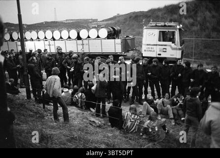 BAN (Break Atomic Chain Netherlands) attua un blocco stradale per impedire che i residui radioattivi provenienti dall'ECN di Petten vengano trasportati su strada fino a IJmuiden, dove saranno spediti per essere scaricati in mare. Dimostrazione. Rifiuti radioattivi. Atomic Waste., Whizgle News, Dutch Desk, Paesi Bassi, 1950 - 2000 il 08-06-1980. Questi sono gli argomenti nell'immagine. La scena cattura un momento di tensione che coinvolge un gruppo di persone riunite in uno spazio chiaramente definito. In primo piano, gli individui sono seduti a terra, alcuni poggiano sull'area erbosa mentre altri appoggiano contro una barriera bassa. Il Foto Stock