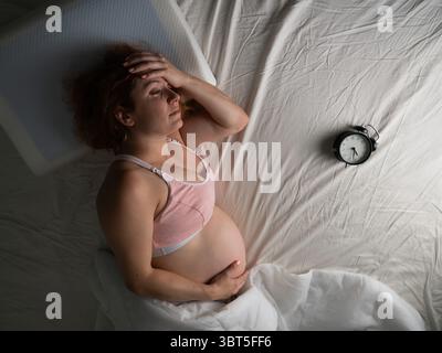 La donna incinta soffre di dolore di notte. Foto Stock