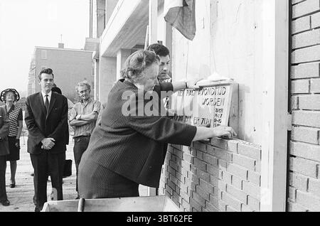 1st Stone Schoterhof First Stone, Whizgle News, Dutch Desk, Paesi Bassi, 1950 - 2000 il 12-10-1970. Questi argomenti sono mostrati nell'immagine. La scena cattura un momento significativo durante un evento cerimoniale incentrato sulla posa di una pietra angolare. In primo piano, due persone sono attivamente impegnate a mettere una pietra in posizione su un muro. La donna, indossando un abito scuro, appare determinata mentre allinea con cura la pietra, mentre un uomo accanto a lei offre assistenza e guida, garantendo che il suo posizionamento sia preciso. Sullo sfondo, una piccola folla si riunisce osservando l'evento. Un uomo in tuta è arguto Foto Stock