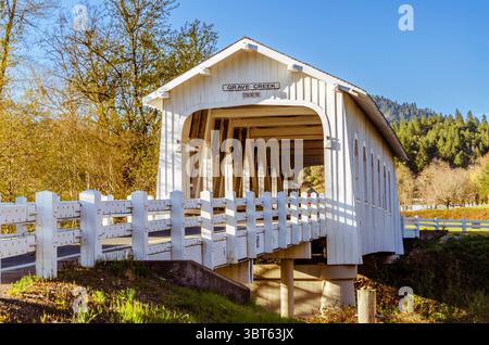 Grave Creek storico ponte coperto in legno nella Sunny Valley, O in primavera. Costruito nel 1920, presenta 12 finestre in stile gotico. Foto Stock
