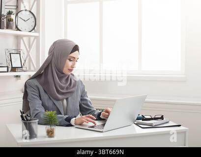 Giovane donna d'affari saudita che lavora in ufficio Foto Stock