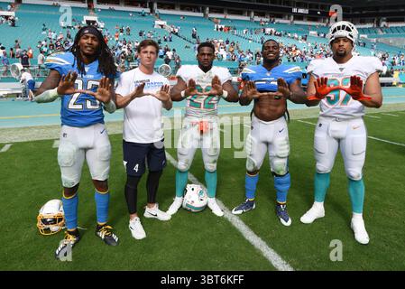 29 settembre 2019: Gli ex-allievi dei Miami Hurricanes Rayshawn Jenkins n. 23, Michael Badgley (t-shirt) e Denzel Perryman n. 52 di Los Angeles posano con Mark Walton n. 22 e Trent Harris n. 97 di Miami durante la partita di football tra Miami Dolphins e Los Angeles Chargers all'Hard Rock Stadium di Miami Gardens. I Chargers sconfissero i Dolphins 30-10.(Credit Image: &Copy; JC Ridley/CSM tramite ZUMA Wire) Foto Stock