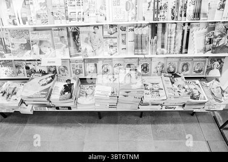 Società di stampa rotocalco VNU VNU Associazione degli editori olandesi, Whizgle News, Dutch Desk, Paesi Bassi, 1950 - 2000 il 14-04-1978. L'immagine include questi argomenti. La scena presenta un'esposizione ben organizzata di riviste disposte su tavoli. Viene visualizzata una serie di copertine in vari colori e design, con un mix di titoli audaci e immagini vivaci. Il primo piano è costituito da caricatori impilati ordinatamente, alcuni appoggiati leggermente di lato, mentre altri sono piatti. Le copertine mostrano una vasta gamma di soggetti, suggerendo moda, stile di vita ed eventualmente intrattenimento. In termini di colore, c'è Foto Stock