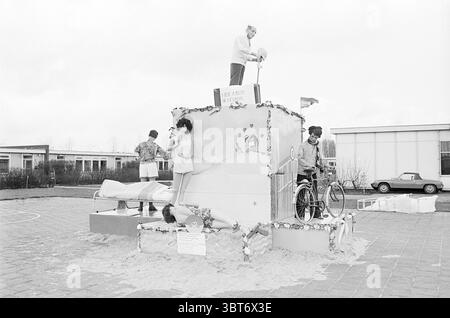 Fallesfeest spagnoli Beverwijk. Party, Whizgle News, Dutch Desk, Paesi Bassi, 1950 - 2000 il 17-03-1975. L'immagine mostra questi argomenti. La scena cattura un vivace evento della comunità incentrato su una grande scultura di sabbia dal design creativo. In prima linea, la scultura presenta più livelli adornati con decorazioni stravaganti, che ricordano un paesaggio fiabesco e giocoso. Su un lato, una figura è raffigurata in piedi trionfalmente, versando quello che sembra essere un liquido da un vaso, aggiungendo un elemento dinamico al pezzo. Accanto a questo, un'altra persona viene catturata in una posa rilassata, il mare Foto Stock