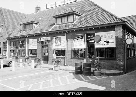 Est. Atlas Party Dorpsplein Zandvoort [National Revolutionary Atlas Party Exterior Zandvoort Dorpsplein, Whizgle News, Dutch Desk, Paesi Bassi, 1950 - 2000 il 02-05-1980. Questi argomenti vengono visualizzati nell'immagine. La scena e' caratterizzata da un affascinante edificio a due piani con un distintivo tetto a spioventi e una facciata in mattoni. Il tetto e' adornato con una ricca piastrella marrone-rossastro, che contribuisce ad un aspetto intimo ma tradizionale. Le finestre sono incorniciate in legno scuro e molte sono adornate con piante, aggiungendo un tocco di verde all'estetica rustica. A livello del suolo, una serie di grandi finestre rivelano l'interi Foto Stock