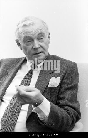 Tjaden Bloemendaal insegnante di inglese - 67 anni persone Bloemendaal, Whizgle News, Dutch Desk, Paesi Bassi, 1950 - 2000 il 20-12-1987. L'immagine include questi argomenti. Un gentiluomo siede comodamente in un ambiente elegante e semplice, vestito con un classico abito grigio che trasuda raffinatezza. Il tessuto della tuta sfoggia una texture delicata, che si abbina a una camicia bianca croccante sotto. La cravatta a motivi aggiunge un tocco di raffinatezza, con dettagli intricati che attirano l'attenzione senza essere esagerati. Ha modellato i suoi capelli con cura, e la sua espressione trasmette meditazione, forse un pizzico di cont Foto Stock