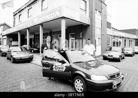 Marshal Honda Company Santpoort Santpoort, Whizgle News, Dutch Desk, Paesi Bassi, 1950 - 2000 il 18-06-1997. Questi argomenti sono mostrati nell'immagine. Nella scena, è raffigurato un vivace showroom automobilistico che mostra una collezione di veicoli parcheggiati in linee pulite. L'attenzione è rivolta a un'auto rossa, in primo piano, dove la porta è aperta, suggerendo un invito a esplorare. Le linee eleganti e la superficie lucida della vettura si distinguono dagli elementi circostanti. Sono presenti due persone: Una si trova con sicurezza accanto all'auto, indossando un abito e trasudando un senso di professionalità Foto Stock