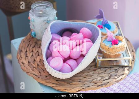 Caramelle rosa insieme a cupcake marroni. Foto Stock