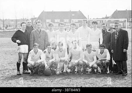 Partita di calcio HBC - ?, Whizgle News, Dutch Desk, Paesi Bassi, 1950 - 2000 nel 1965. L'immagine contiene questi argomenti. In un ambiente all'aperto illuminato dal sole, un gruppo di giovani uomini si erge su due file su un terreno erboso, con i loro dintorni caratterizzati da alberi sparsi e edifici residenziali sullo sfondo. I giocatori sono vestiti con maglie e pantaloncini bianchi abbinati, alcuni calzini sportivi sono tirati in alto. Le loro espressioni vanno dal serio al sorriso, indicando un mix di cameratismo e concentrazione. In prima fila, diversi individui si inginocchiano, con uno che regge un pallone da calcio. La fila posteriore ne include alcuni alti Foto Stock