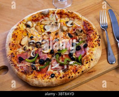 Pizza doppia servita su tavola di legno Foto Stock
