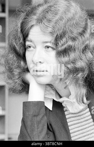 Home Advice shop shop e chioschi, Whizgle News, Dutch Desk, Paesi Bassi, 1950 - 2000 il 05-09-1972. L'immagine contiene questi argomenti. In questa scena, una donna è raffigurata con capelli voluminosi e ricci che incornicia il suo viso in onde morbide. Ha caratteristiche delicate e un'espressione contemplativa, con il mento appoggiato sulla mano, suggerendo un momento di introspezione. L'illuminazione è morbida e diffusa, emettendo ombre delicate che esaltano la texture dei suoi capelli e i contorni sottili del suo viso. Lo sfondo è leggermente sfocato ma suggerisce un ambiente interno con pareti e ripiani dai toni neutri Foto Stock