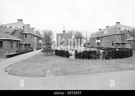 Pavilion Foundation] Vogelenzang, Whizgle News, Dutch Desk, Paesi Bassi, 1950 - 2000 il 25-01-1993. Questi sono gli elementi dell'immagine. La scena cattura un quartiere residenziale caratterizzato da un gruppo di edifici in mattoni disposti intorno a uno spazio verde centrale. L'architettura presenta un mix di basse strutture, ognuna con tetti a spiovente e varie finestre posizionate, creando un layout un po' simmetrico. In primo piano, un percorso circolare si snoda attraverso l'erba, delimitata da siepi ben rifilate e macchie di terra. L'erba sembra ben mantenuta, anche se l'assenza Foto Stock