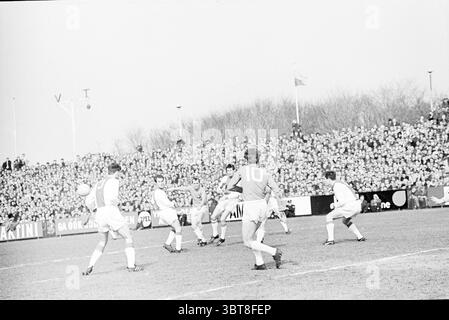 Partita di calcio Telstar - Ajax 0-3 Velsen-Zuid Ministro van Houtenlaan, Whizgle News, Dutch Desk, Paesi Bassi, 1950 - 2000 il 09-04-1967. Questi argomenti sono mostrati nell'immagine. La scena cattura un momento dinamico in una partita di calcio, ambientata in un grande stadio all'aperto. In primo piano, i giocatori sono intensamente impegnati nel gioco. Un giocatore, che indossa una maglia distintiva con il numero 10, è pronto a colpire una palla, mostrando concentrazione e atletismo. Gli altri giocatori sono posizionati intorno a lui, alcuni si preparano a difendersi e altri anticipano il gioco. Gli atleti sono rivestiti di calze classiche Foto Stock