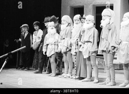 Rivista per bambini Kennedyschool IJmuiden Children Children's Homes Children's Party Children's Theater IJmuiden Paesi Bassi, Whizgle News, Dutch Desk, Paesi Bassi, 1950 - 2000 il 24-01-1985. L'immagine contiene questi argomenti. La scena cattura uno spettacolo teatrale con un gruppo di bambini in formazione su un palco. Sono vestiti con vivaci costumi, ognuno caratterizzato da colori vivaci come rossi, blu e verdi audaci, contrastati da bianchi e beige morbidi che ricordano l'abbigliamento invernale. Molti dei bambini hanno la barba bianca, indicando che potrebbero ritrarre personaggi come Foto Stock