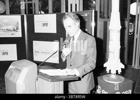 Prima pila + firma ESTEC Noordwijkerhout prima pila Space Noordwijkerhout, Whizgle News, Dutch Desk, Paesi Bassi, 1950 - 2000 il 26-10-1989. Questi argomenti sono mostrati nell'immagine. La scena è ambientata all'interno, probabilmente in uno spazio espositivo o in un centro congressi. La figura centrale, un uomo con un abito sartoriale, è posizionata su un podio dal design elegante e moderno. La sua espressione trasmette concentrazione e determinazione mentre gestiva con una mano, forse sottolineando un punto nel suo discorso. Dietro di lui, ci sono grandi bacheche con immagini e informazioni su un evento spaziale, likel Foto Stock