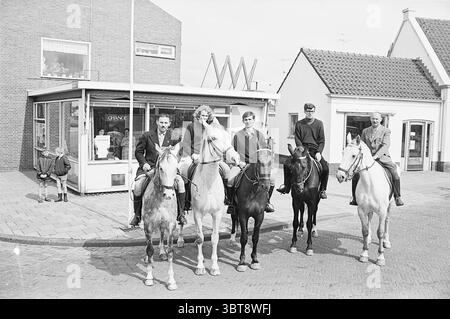 Cavalieri a cavallo di fronte all'edificio dell'ufficio turistico, Whizgle News, Dutch Desk, Paesi Bassi, 1950 - 2000 il 19-06-1964. Questi sono gli elementi dell'immagine. Nella scena, un gruppo di cinque individui è posizionato in modo prominente in cima ai loro cavalli, creando un punto focale impressionante sullo sfondo di un pittoresco ambiente urbano. I cavalli hanno colori diversi, tra cui un bianco e tonalità più scure, aggiungendo un contrasto visivo alla composizione complessiva. I motociclisti sono vestiti con abiti sartoriali, suggerendo un contesto formale o storico. Le loro espressioni vanno dal serio al allegro, sug Foto Stock