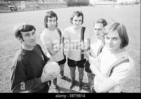 Football Players, Whizgle News, Dutch Desk, Paesi Bassi, 1950 - 2000 il 06-09-1971. Questi sono gli elementi dell'immagine. In un vivace ambiente all'aperto, un gruppo di cinque giovani uomini si riunisce con fiducia e le loro posture trasmettono cameratismo e determinazione. In primo piano c'è una persona che tiene in mano un classico pallone da calcio in bianco e nero, con il corpo leggermente angolato verso lo spettatore, creando un senso di coinvolgimento. Ogni persona mostra un'espressione unica che aggiunge carattere all'ensemble; alcuni indossano sorrisi sottili mentre altri mantengono un aspetto più serio, suggerendo un mix di per Foto Stock