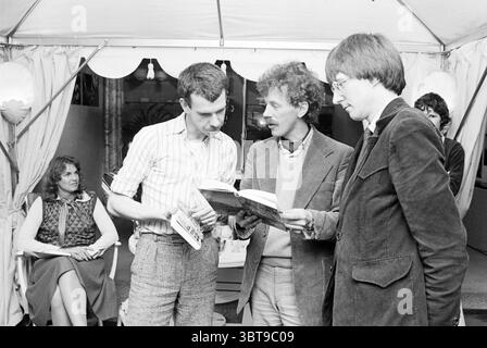 Libro di presentazione 'A Garden for Yourself' Zeist' Spectrum Zeist, Whizgle News, Dutch Desk, Paesi Bassi, 1950 - 2000 il 14-03-1979. L'immagine include questi argomenti. In un ambiente vivace e accogliente, un gruppo di quattro persone si impegna in animate discussioni. La scena è adornata da un'illuminazione soffusa e calda che emana dalle lampadine sopra la testa sotto una struttura simile a una tenda, creando un'atmosfera invitante. Due uomini stanno vicini, concentrati su un libro che si tiene aperto tra di loro. L'uomo a sinistra ha una struttura sottile, indossa una camicia a maniche corte a righe e pantaloni di colore chiaro, che mostrano un sen Foto Stock