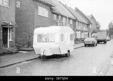 Caravan in Beverwijk Street Caravan camp Caravan Residents, Whizgle News, Dutch Desk, Paesi Bassi, 1950 - 2000 il 28-06-1978. Questi argomenti sono mostrati nell'immagine. La scena cattura una tranquilla strada residenziale fiancheggiata da modeste case in mattoni, ognuna caratterizzata da stili architettonici distintivi. Le case hanno tetti inclinati, alcune adornate con piccoli balconi e grandi finestre che riflettono un ambiente tranquillo di quartiere. Parcheggiata lungo la strada acciottolata si trova una carovana bianca, ben posizionata, con una forma leggermente arrotondata e un design semplice. L'esterno è pulito, co Foto Stock