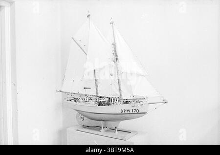 Modello di una fresa a due alberi SPM 170., Whizgle News, Dutch Desk, Paesi Bassi, 1950 - 2000. Questi argomenti sono mostrati nell'immagine. La scena presenta un modello dettagliato di una nave esposta in modo prominente su un piedistallo. La nave, con lo scafo elegantemente ricurvo, presenta una combinazione di bianco e sfumature di grigio, enfatizzando il suo design classico. La vela è realizzata in tessuto sottile e morbido, che oscilla leggermente come se fosse catturata da una leggera brezza. Il rigging è realizzato meticolosamente, con piccole corde e pulegge che aggiungono un tocco di autenticità al modello. La cura artigianale rivela dettagli complessi, f Foto Stock