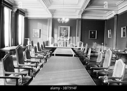 Interno del college Hageveld nella sala riunioni Heemstede con dipinti Heemstede Paesi Bassi, Whizgle News, Dutch Desk, Paesi Bassi, 1950 - 2000 al 25-10-1979. L'immagine include questi argomenti. La scena presenta una camera spaziosa ed elegantemente progettata con alti soffitti adornati da intricate modanature. Le pareti sono dipinte in un colore profondo e ricco che contrasta con la luce proveniente da grandi finestre alte. La luce del sole proietta ombre allungate sul pavimento, migliorando il senso di profondità nello spazio. Al centro della sala c'è un lungo tavolo rettangolare per conferenze, lucido e di colore scuro, Foto Stock