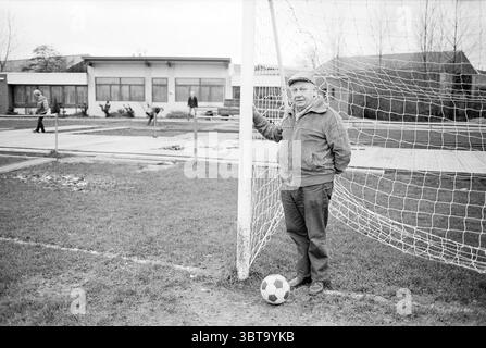 Il signor Broekhuysen presidente jubilee Comm. Sizo Football, Whizgle News, Dutch Desk, Paesi Bassi, 1950 - 2000 il 24-11-1982. Questi sono gli elementi dell'immagine. La scena presenta un campo da calcio erboso, in cui un uomo si trova accanto a un paliotto, appoggiandosi casualmente contro di esso. È vestito con una giacca calda, tira fuori un comportamento rilassato e guarda lo spettatore con un leggero sorriso. Ai suoi piedi si trova un classico pallone da calcio bianco e nero, che si aggiunge all'atmosfera atletica dell'ambiente. In background, diversi individui sono impegnati in varie attività sul campo. Alcuni sembrano essere praticabili Foto Stock