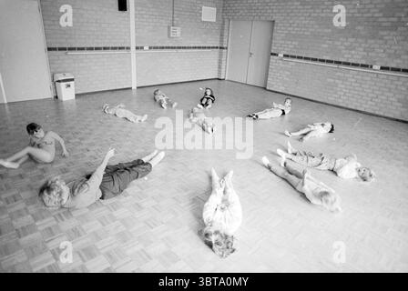 Lezioni di balletto di Corine Koelma Velserbroek Velserbroek, Whizgle News, Dutch Desk, Paesi Bassi, 1950 - 2000 il 08-10-1990. Questi sono gli argomenti nell'immagine. In una camera spaziosa e ben illuminata con pavimento in legno lucido, un gruppo di bambini si estende in varie posizioni, ognuno impegnato in un'attività ludica. Le pareti sono un beige delicato, completato da un sottile motivo a griglia di mattoni a vista, che donano allo spazio un'atmosfera calda e invitante. I bambini, un mix della loro età, sono vestiti con abiti di colore chiaro; alcuni sono in tonalità pastello mentre altri sfoggiano tonalità più luminose. I loro capelli variano da Foto Stock