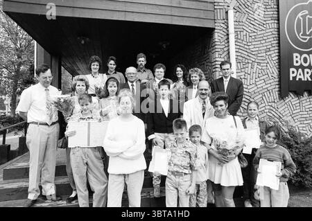 Vincitori del premio dell'associazione Cronjé di fronte all'ingresso del Claus Bowling & Partyhouse Haarlem Orionweg Paesi Bassi, Whizgle News, Dutch Desk, Paesi Bassi, 1950 - 2000 il 11-05-1991. Questi argomenti vengono visualizzati nell'immagine. La scena cattura un gruppo eterogeneo di persone riunite all'esterno di un edificio con una facciata testurizzata, caratterizzata da un motivo unico che aggiunge profondità all'ambiente. Il gruppo sembra celebrare un'occasione significativa, poiché molti stanno tenendo mazzi di fiori o documenti, suggerendo un senso di realizzazione o di festa. In primo piano, un paio Foto Stock