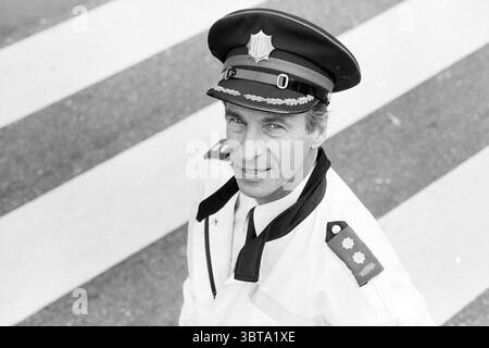 Van Diepen, capo della polizia stradale, Whizgle News, Dutch Desk, Paesi Bassi, 1950 - 2000 il 10-10-1991. L'immagine mostra questi argomenti. La scena cattura un agente delle forze dell'ordine in piedi con sicurezza su un passaggio pedonale. È vestito con una divisa bianca e croccante, che contrasta nettamente con i suoi pantaloni scuri. L'uniforme è decorata con spalline che portano insegne, aggiungendo un tocco di autorità. Il suo berretto, con un distintivo lucente, si siede perfettamente in cima alla sua testa, incorniciando il suo volto. L'espressione dell'ufficiale è calma e disponibile, trasuda un senso di professionalità. Foto Stock