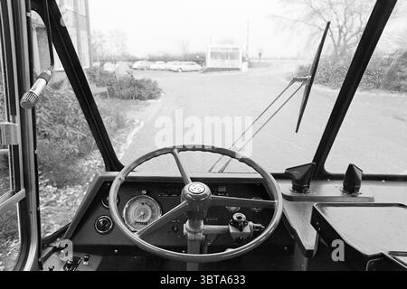 Road test bus 1041 Noord Zuid Hollandse Vervoersmaatschappij N.V. NZ Verheul Carosseriefabriek Waddinxveen, Whizgle News, Dutch Desk, Paesi Bassi, 1950 - 2000 il 24-01-1968. Questi sono gli elementi dell'immagine. La scena presenta una visuale dal punto di vista del sedile del conducente all'interno di un veicolo. Il punto focale è il volante, ampio e circolare, montato davanti a un cruscotto dotato di diversi indicatori e manopole, che indicano la funzionalità del veicolo. La ruota è caratterizzata da un design semplice, probabilmente realizzato con un materiale scuro che contrasta con il tono più chiaro Foto Stock