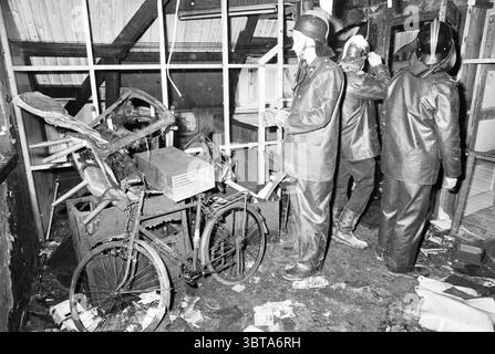 Pavimento bruciato di Valkenburgerlaan Heemstede vigili del fuoco Heemstede Valkenburgerplein Paesi Bassi, Whizgle News, Dutch Desk, Paesi Bassi, 1950 - 2000 il 01-03-1981. L'immagine mostra questi argomenti. La scena raffigura un ambiente interno caotico, caratterizzato da un netto contrasto tra luce e ombra. L'interno sembra essere uno spazio improvvisato, ingombrante di detriti e disordine. Materiali scuri e pesanti dominano l'ambiente, con una miscela di toni neri e terreni tenui che creano un'atmosfera cupa. In primo piano, una vecchia bicicletta si trova socchiusa, il suo telaio è parzialmente oscurato Foto Stock