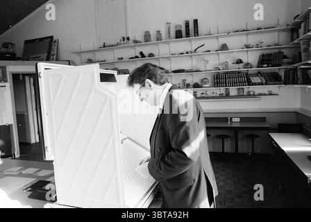 Wallage lancia il suo voto, Whizgle News, Dutch Desk, Paesi Bassi, 1950 - 2000 il 02-05-1994. Questi sono gli elementi dell'immagine. La scena raffigura un ambiente interno che trasuda un senso di curiosità e nostalgia. Un uomo di mezza età, vestito con una tuta scura, sta di profilo, esaminando intensamente un grande armadio aperto. Il cabinet presenta un design distintivo e strutturato con una superficie bianca testurizzata, che indica lo scopo per l'esposizione o lo stoccaggio di articoli. Sullo sfondo, una serie di ripiani rivestono le pareti, mostrando vari oggetti che sembrano spaziare dagli strumenti scientifici agli strumenti decorativi Foto Stock