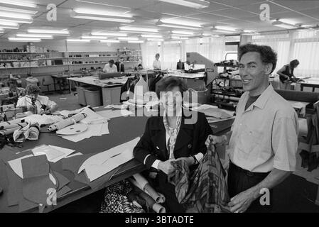 Mirabel Fashion Sewing studio, Whizgle News, Dutch Desk, Paesi Bassi, 1950 - 2000 il 01-06-1994. Questi argomenti vengono visualizzati nell'immagine. La scena presenta uno spazioso laboratorio tessile, pieno di attività. In primo piano, due persone spiccano: Una donna dai capelli corti e con un blazer nero sartoriale, che trasuda fiducia mentre sorride dolcemente. Accanto a lei, un uomo dai capelli pettinati tiene un tessuto a fantasia, mostrando un senso di orgoglio per la sua abilità. Il loro abbigliamento suggerisce un ambiente professionale, sottolineando l'ambiente incentrato sull'abbigliamento. L'officina stessa è Expansi Foto Stock