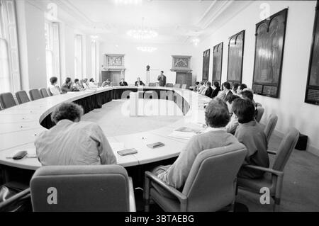 EQ. media riorganizzazione Haarlem Haarlem Paesi Bassi, Whizgle News, Dutch Desk, Paesi Bassi, 1950 - 2000 il 29-05-1991. L'immagine include questi argomenti. La scena raffigura una riunione formale che si svolge in una sala conferenze spaziosa e ben illuminata. L'ambiente presenta un grande tavolo ovale allungato circondato da numerose sedie imbottite, che sottolineano un senso di unità e collaborazione tra i partecipanti. Le pareti sono adornate da grandi finestre che permettono alla luce naturale di inondare la sala, creando un'atmosfera luminosa e aperta. La tavolozza dei colori è prevalentemente neutra, con sfumature di bianco, Foto Stock