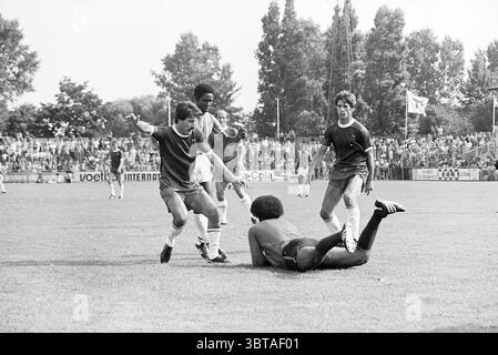 Haarlem - Robin Hood Football Haarlem, Whizgle News, Dutch Desk, Paesi Bassi, 1950 - 2000 il 15-08-1976. L'immagine include questi argomenti. In un ambiente sportivo vivace, un gruppo di quattro atleti viene catturato in un momento dinamico su un campo erboso, circondato da una folla entusiasta. I giocatori indossano maglie abbinate, prevalentemente nelle tonalità blu scuro e rosso, con pantaloncini variegati che si abbinano ai colori audaci dei loro top. Tra questi, un giocatore si trova trionfalmente con le braccia allungate, trasudando un'energia esuberante, mentre altri due si impegnano da vicino, probabilmente celebrando o stratega Foto Stock