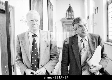 I consiglieri CDA si dimisero dal Consiglio municipale di Haarlem, Whizgle News, Dutch Desk, Paesi Bassi, 1950 - 2000 il 14-10-1980. Questi sono gli argomenti nell'immagine. In un corridoio stretto e ben illuminato, due uomini camminano fianco a fianco, trasudando un senso di cameratismo e deliberazione. Le pareti sono adornate da opere d'arte incorniciate che suggeriscono un ambiente storico, mentre le grandi finestre consentono alla luce naturale di filtrare, creando un'atmosfera calda e invitante. Il primo individuo, sulla sinistra, ha un'espressione composta, sfoggiando un abito di colore chiaro con un sottile motivo a spina di pesce, completato da una cravatta a motivi geometrici. Suo Foto Stock