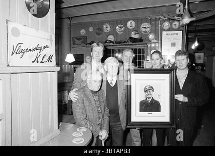 Café De Uiver Family party, Whizgle News, Dutch Desk, Paesi Bassi, 1950 - 2000 il 03-12-1993. L'immagine mostra questi argomenti. In un ambiente caldo e rustico, un gruppo eterogeneo di sei persone si riunisce da vicino, creando un senso di cameratismo. Lo sfondo presenta pareti in legno adornate con vari piatti vintage e cimeli che aggiungono carattere alla camera. Davanti, un uomo anziano siede su un bastone, trasuda saggezza con un sorriso gentile e vestito con un maglione a motivi geometrici. Intorno a lui ci sono altri quattro adulti, un mix di uomini e una donna, tutti vestiti casualmente. Si postura con fiducia, highlighti Foto Stock