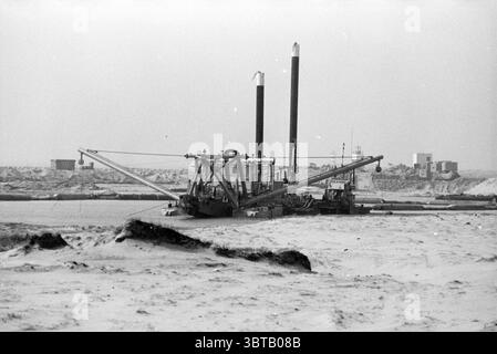 Piano spiaggia IJmuiden, Whizgle News, Dutch Desk, Paesi Bassi, 1950 - 2000 il 15-04-1993. L'immagine contiene questi argomenti. La scena raffigura un paesaggio industriale feroce dominato da una grande macchina da dragaggio collocata in un ambiente sabbioso e arido. La macchina è robusta e presenta due tubi verticali alti che si estendono verso l'alto, creando un senso di altezza e presenza sullo sfondo silenzioso. È affiancato da braccia lunghe e pesanti che si estendono verso l'esterno, suggerendo movimenti e funzioni come se fossero attivamente impegnati in un compito. Intorno alla macchina, il terreno appare desolato, con tratti lisci, Foto Stock