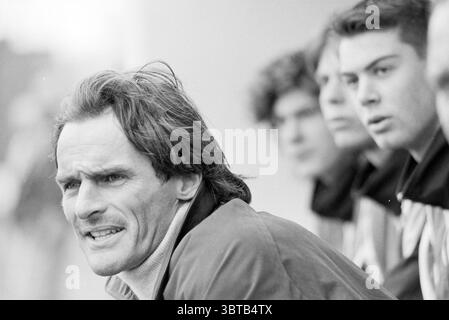 Calciatore Jan Olde Riekerink di Telstar ad Alkmaar Alkmaar, Whizgle News, Dutch Desk, Paesi Bassi, 1950 - 2000 il 05-03-1993. L'immagine include questi argomenti. La scena cattura un gruppo di individui in un momento dinamico, mostrando un mix di emozioni ed espressioni. In primo piano, un uomo con una forte mandibola e capelli leggermente sbiaditi trasmette intensità. La sua espressione è acuta, con una fronte solcata e uno sguardo focalizzato, evocando determinazione o forse preoccupazione. Indossa una giacca con zip che contrasta con l'abbigliamento più casual delle persone dietro di lui. Dietro di lui CE ne sono tre Foto Stock