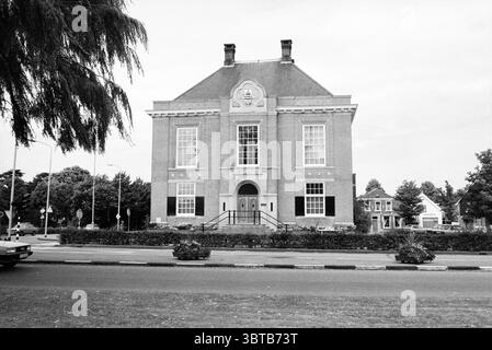Esterno del Polderhuis sul Marktplein a Hoofddorp. Dal 1979 il centro amministrativo del bacino idrico di Groot-Haarlemmermeer si trova qui. Hoofddorp Marktplein Paesi Bassi, Whizgle News, Dutch Desk, Paesi Bassi, 1950 - 2000 il 06-08-1980. Questi sono gli elementi dell'immagine. La scena presenta un grande e maestoso edificio con un'imponente facciata in mattoni. La struttura è caratterizzata da un design simmetrico, evidenziato da alte e strette finestre che fiancheggiano un ingresso centrale. L'entrata presenta una serie di scalini che portano a doppie porte, che sono ornamentali dettagliate. L'uppe Foto Stock