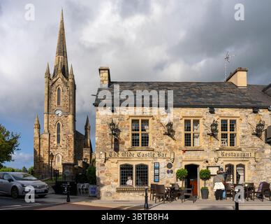 Donegal Town Church of Ireland con guglia e torre dell'orologio accanto all'Olde Castle Bar and Restaurant nella città di Donegal, Contea di Donegal, Irlanda. Foto Stock