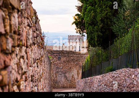 Percorso impostato tra secolari mura in pietra nella splendida Assisi in Italia Foto Stock