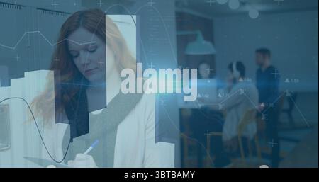 Donna dai capelli rossi che indossa un blazer che utilizza gli appunti nell'area di copia dell'ufficio, con stampanti, spazio per le copie Foto Stock