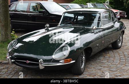 Bad Bentheim, Germania - 4 maggio 2025 la parte anteriore di una Jaguar e-TYPE verde scuro dal 1969. E' parcheggiato tra altri vecchi tempi Foto Stock