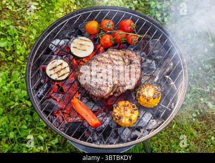 bistecca di manzo e verdure su griglia a carbone, vista dall'alto Foto Stock