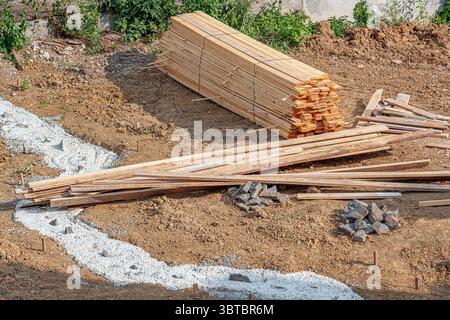 Le tavole di legno impilate sono impilate in modo ordinato su un cantiere all'aperto Foto Stock