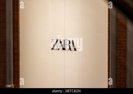 Poznan, Polonia - 30 giugno 2025: L'iconico logo nero DI ZARA è esposto su un elegante edificio minimalista, che simboleggia le tendenze della moda contemporanea e. Foto Stock