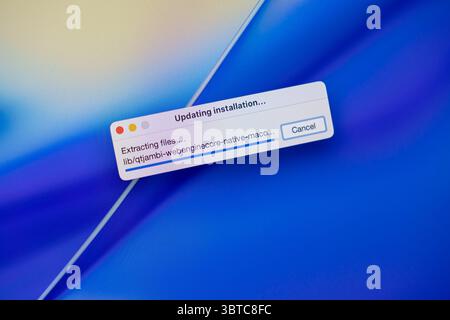 Poznan, Polonia - 30 giugno 2025: Vista ravvicinata di uno schermo digitale che mostra un aggiornamento software, visualizza l'aggiornamento l'installazione e l'estrazione di file pro Foto Stock